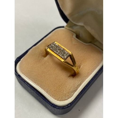 27 - A diamond three stone ring, with bifurcated shoulders and set in 18ct gold -