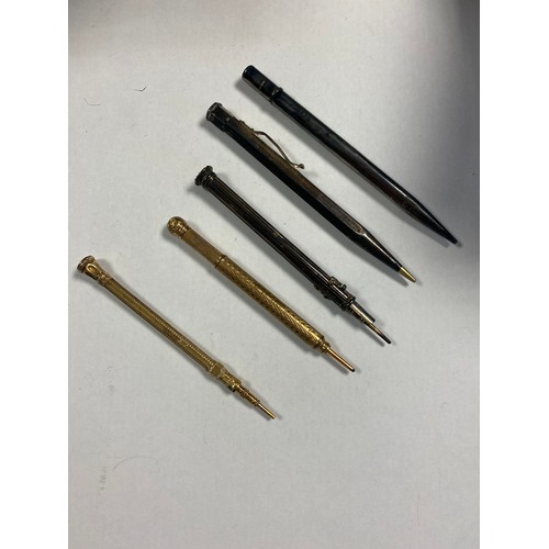 5 - A group of five propelling pencils, including a gold tone pencil with stone inset end -