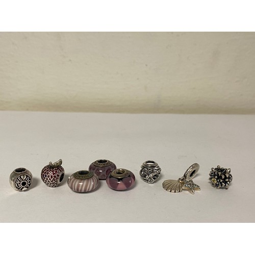 27 - A group of eight silver Pandora charms and spacer beads, including crystal set apple and flowerheads... 