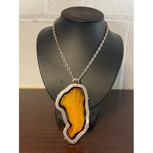 36 - A large modern amber pendant, with silver frame mount and on silver chain -