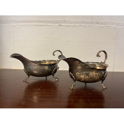 38 - A pair of silver sauce boats, makers marks rubbed, with acanthus handles and hoof feet -