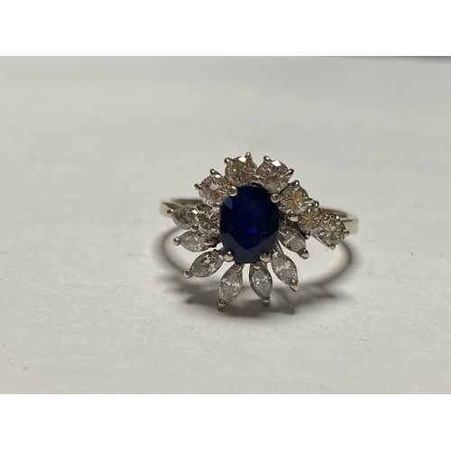 104 - A sapphire and diamond dress ring, set with an oval sapphire within a border of round and marquise c... 