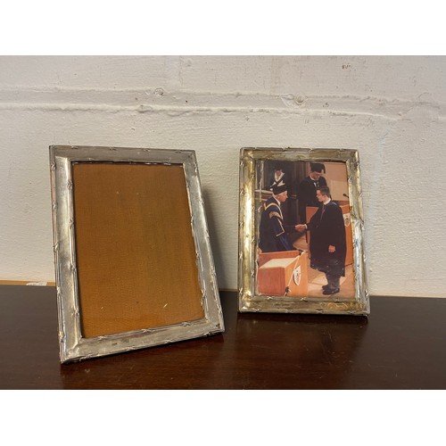 109 - A near pair of silver faced photograph frames, marks rubbed, one with easel back -