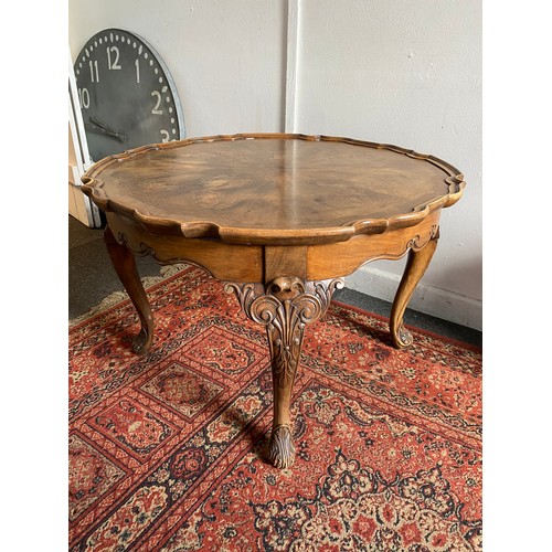 406 - A walnut veneered pie crust occasional table, on leaf and scroll capped legs and feet -