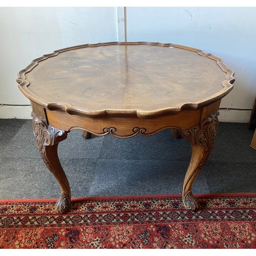 406 - A walnut veneered pie crust occasional table, on leaf and scroll capped legs and feet -