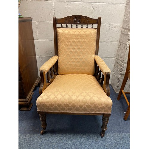 408 - An Edwardian library style armchair, with carved top rail, upholstered back, arms and seat and turne... 