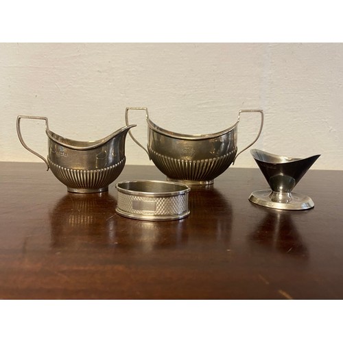 29 - A small group of silver items, various dates and makers, comprising cream jug and sugar bowl, egg cu... 