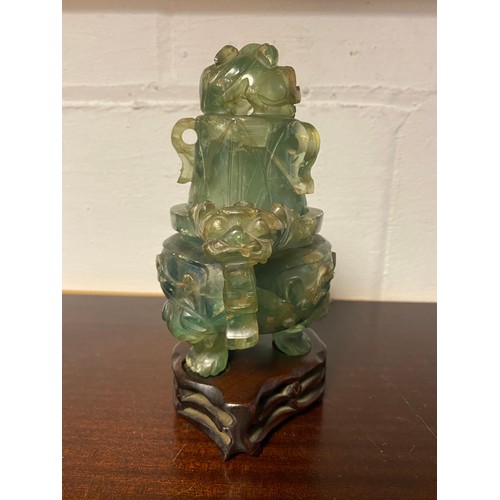 61 - A Chinese fluorite censer and cover, with carved and pierced decoration, on carved hardwood stand -