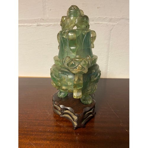 61 - A Chinese fluorite censer and cover, with carved and pierced decoration, on carved hardwood stand -