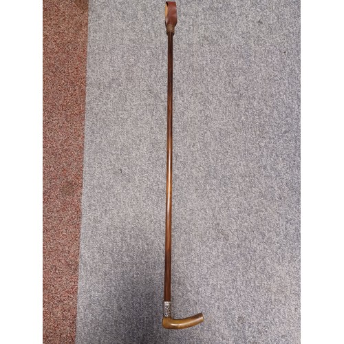 344 - An early 20th century riding crop, with horn handle and silver collar -