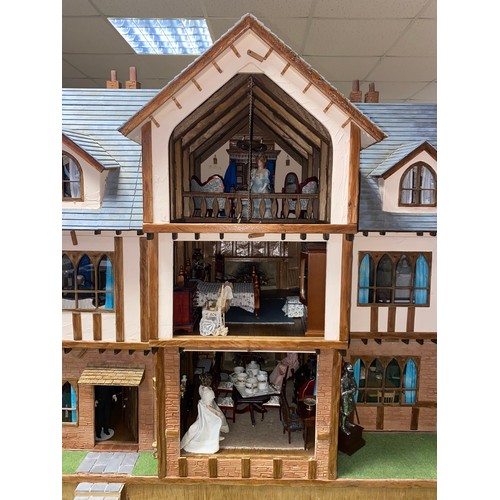 128 - A large three storey dolls house, designed as a mock Tudor house called Romen, with nine rooms, toge... 