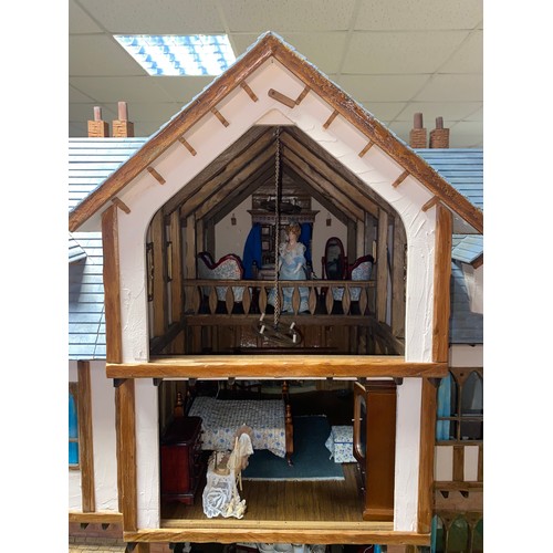 128 - A large three storey dolls house, designed as a mock Tudor house called Romen, with nine rooms, toge... 