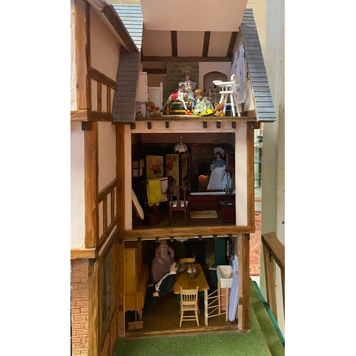 128 - A large three storey dolls house, designed as a mock Tudor house called Romen, with nine rooms, toge... 