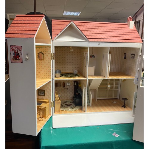 129 - A dolls house/shop, with shop front, eight further rooms, the lift top attic with electrics, togethe... 