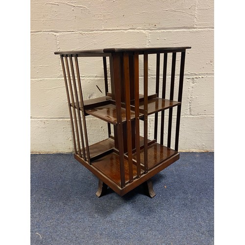 269 - An Edwardian mahogany revolving bookcase, of small size, with shaped top and open shelves -