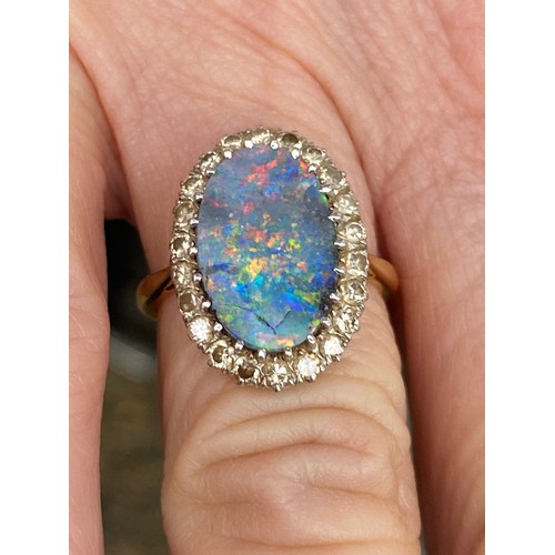 21 - A black opal and diamond cluster ring, the large black opal claw set in a border of single cut diamo... 