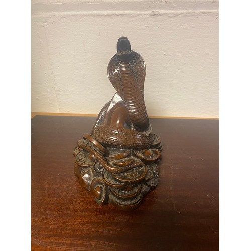 94 - A hardwood Chinese carving, depicting a rearing snake on a pile of coins -