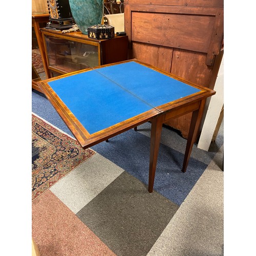 404 - An Edwardian inlaid foldover card table, on square  tapering legs -