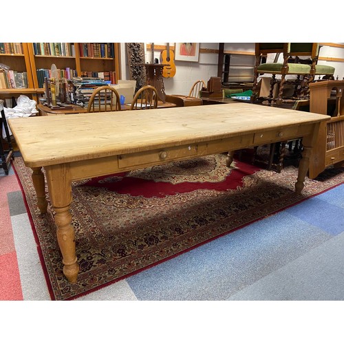 441 - A stripped pine farmhouse table with two side drawers, together with ten bar back chairs -