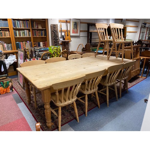 441 - A stripped pine farmhouse table with two side drawers, together with ten bar back chairs -