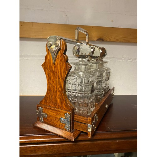 129 - A Mappin & Webb 'The Cabinet' oak and silver plated tantalus, with three cut glass decanters, each w... 