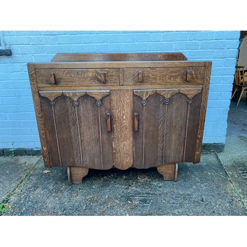 447 - An oak sideboard, fitted with two drawers over cupboard doors -