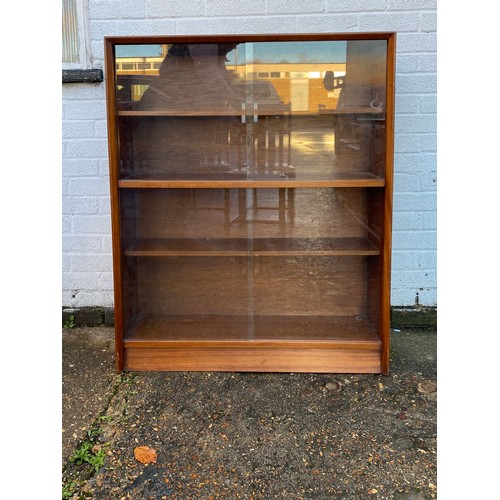 448 - A glass fronted bookcase, fitted with two pairs of sliding doors -