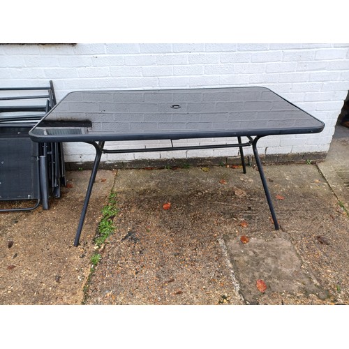 472 - A garden table and six folding chairs -