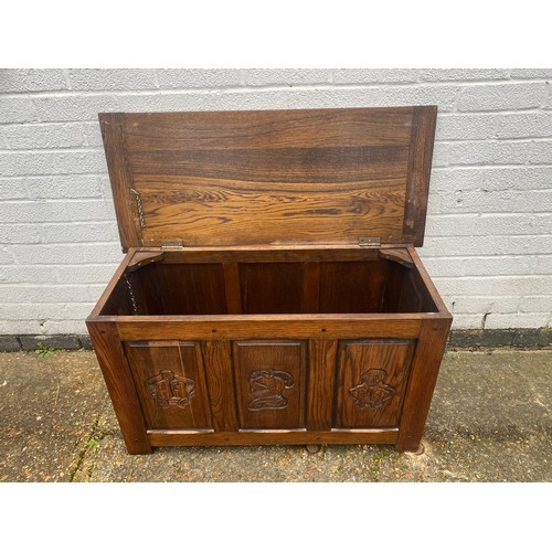 404 - An oak blanket box, carved with knights helmets to front -