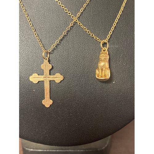 63 - A 9ct gold cross pendant on chain, and a 9ct cat on chain -