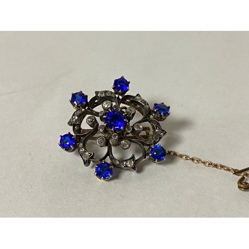 92 - An Edwardian pendant/brooch, of knot design and set with diamonds and blue stones, in precious metal... 