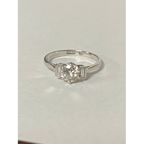 123 - A diamond three stone ring, with brilliant cut diamond flanked by baguette diamonds set in 18ct whit... 