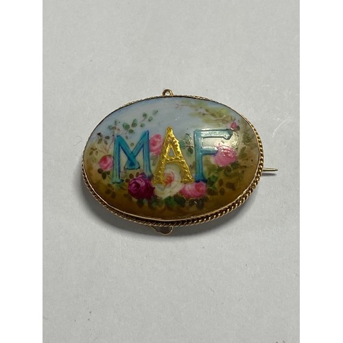 15 - A Victorian 15ct gold brooch, set with a floral painted panel with the initials MAF -