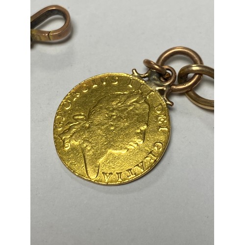 60 - A yellow metal chain, with 9ct gold dog clip, suspending an 1802 George III half guinea and two othe... 