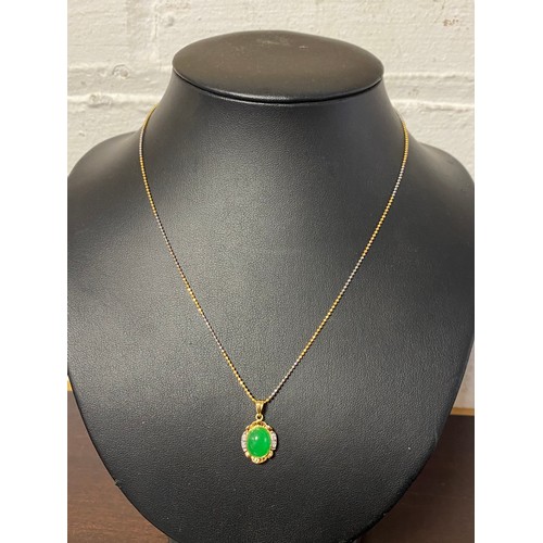 77 - A 14ct gold pendant, set with oval green stone and diamond points, to bi-coloured 18ct chain -