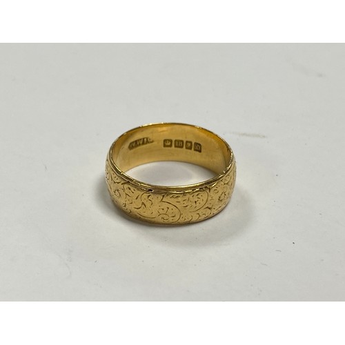 95 - An 18ct gold band ring, with engraved decoration -