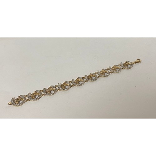 1 - A modern 9ct gold bracelet, composed of a line of horseshoes and horseheads, set with clear and red ... 