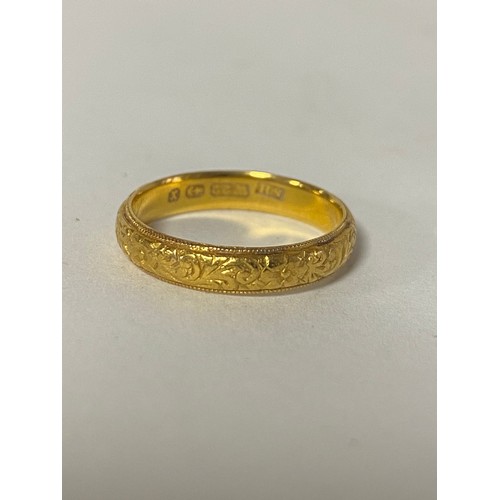 18 - A 22ct gold wedding band, with engraved decoration -