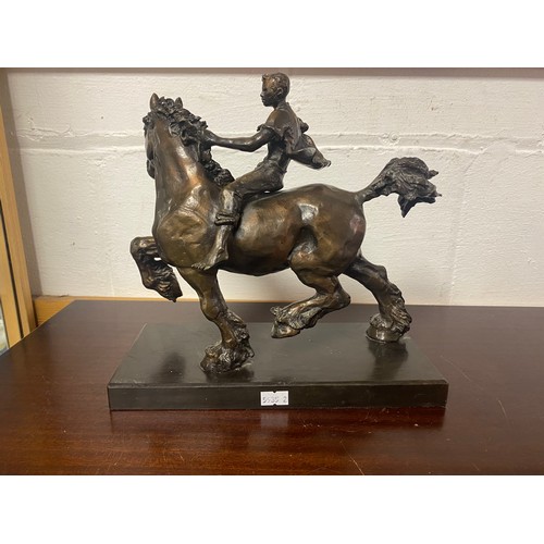 54 - A modern bronze of a boy riding a horse -