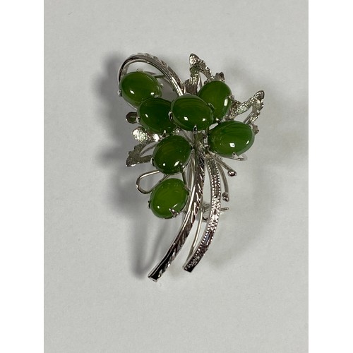 29 - A white metal brooch, set with green stones in a foliate design -