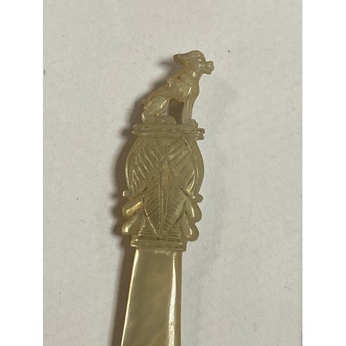 77 - A 19th century mother-of-pearl 'Grand Tour' desk clip, surmounted by a carved dog, together with  a ... 