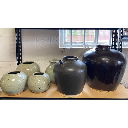 82 - Two brown glazed ewers and four other pots -