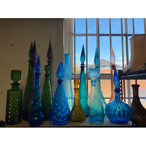 89 - A quantity of coloured glass genie bottles and other decanters etc -