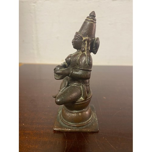 140 - A bronze of a seated deity -