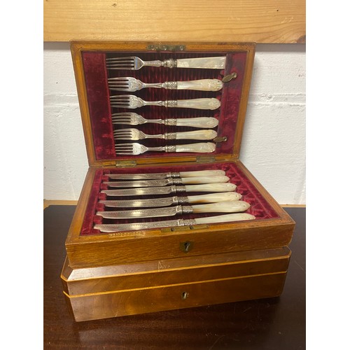 39 - A cased set of dessert knives and forks, with mother-of-pearl handles, and a set of fish eaters -