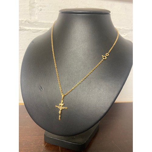 134 - An 18ct gold crucifix pendant to 9ct gold chain -