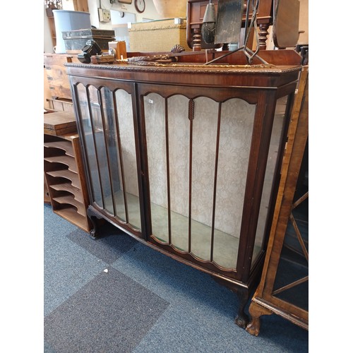 295 - A mahogany finish bow fronted display cabinet, on claw and ball feet -