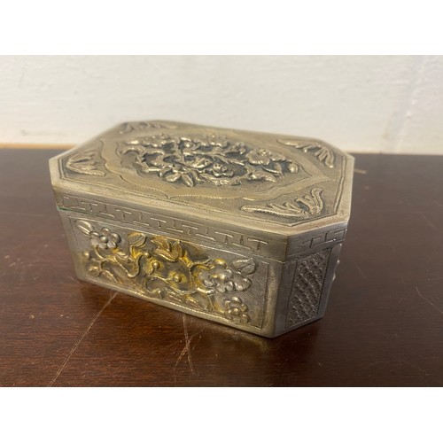 14 - A Chinese white metal box, with canted corners, decorated with panels of flowers -