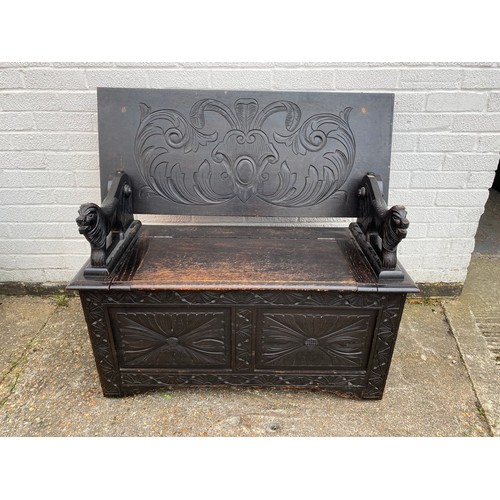 326 - An oak monks bench,
with carved lion supports -