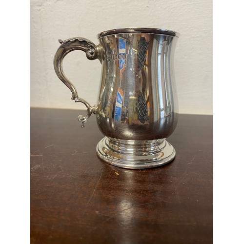 68 - A modern silver mug, London 1960, with leaf scrolled handle -